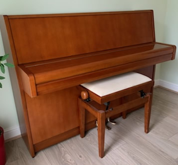 Yamaha upright piano in a walnut cabinet.