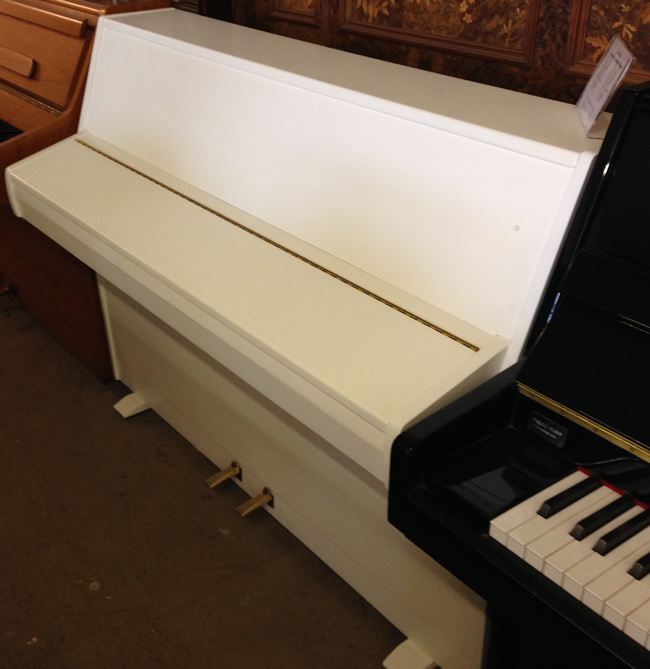 Sideview of white zender piano.