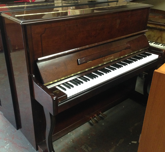 Gratiae upright piano in a Mahogany high gloss finish.