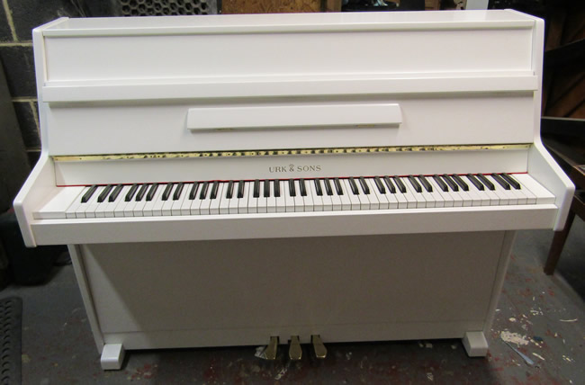Urk & Sons white satin modern upright piano.