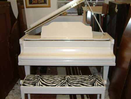 Restored and repolished White baby grand pianos.